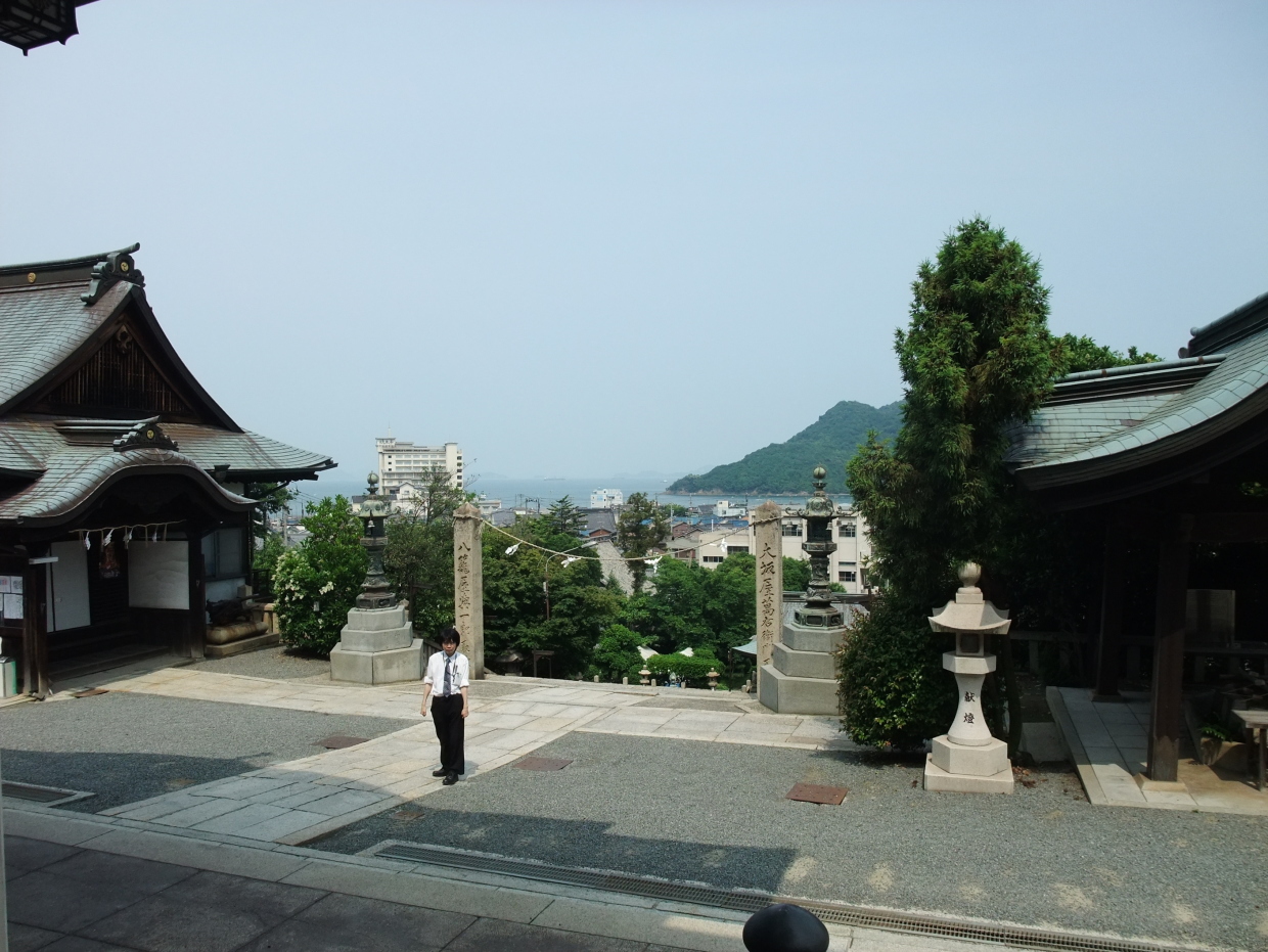 沼名前神社(ぬなくま じんじゃ)境内の増田真知宇(ますだまちう)先生、向こうに瀬戸内海と仙酔島が見えます 沼名前神社(ぬなくま じんじゃ)境内の増田真知宇(ますだまちう)先生、向こうに瀬戸内海と仙酔島が見えます