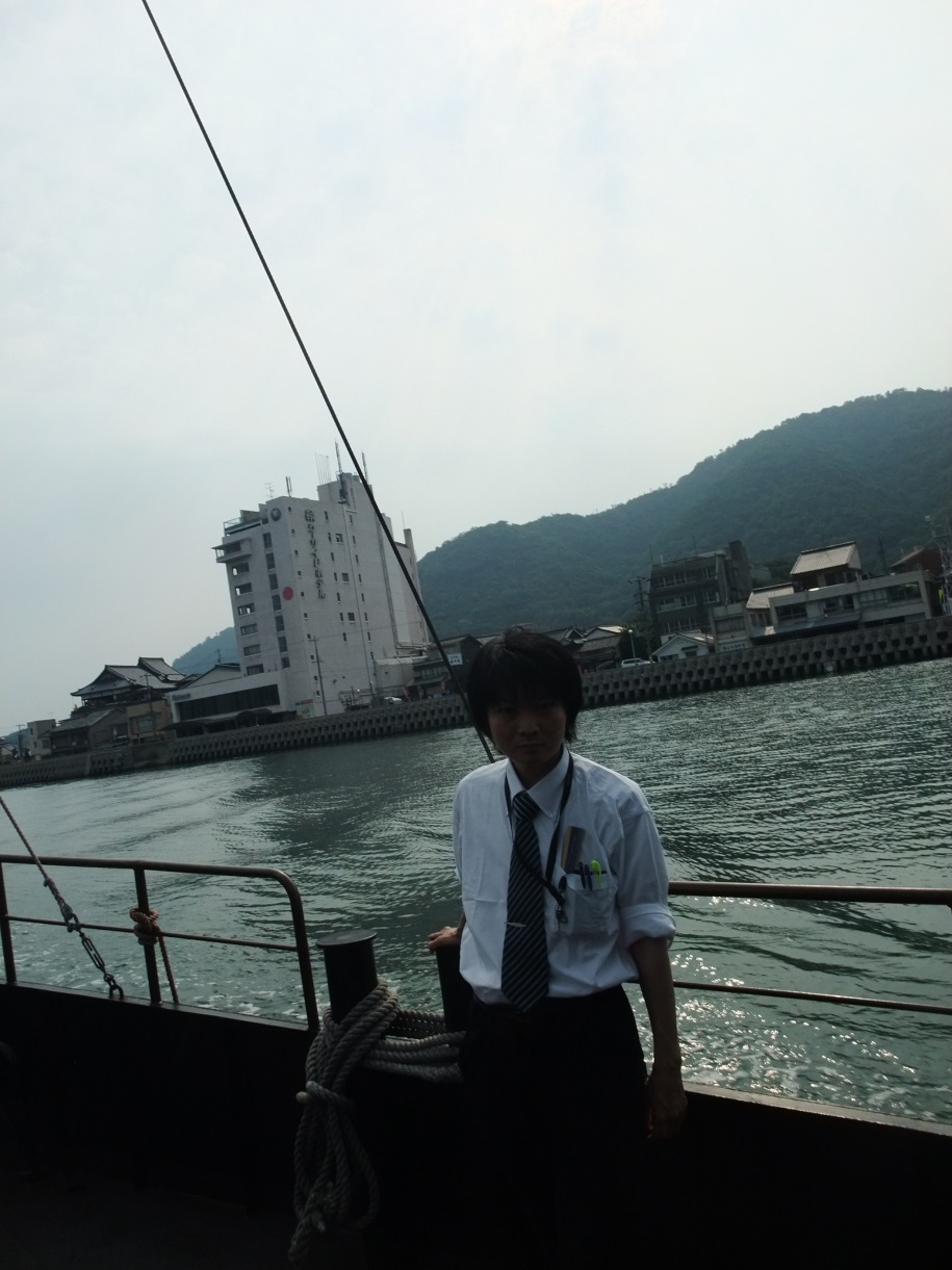 鞆の浦から仙酔島へ向かうフェリーに乗る増田真知宇(ますだまちう)先生。背景に鞆シーサイドホテル 鞆の浦から仙酔島へ向かうフェリーに乗る増田真知宇(ますだまちう)先生。背景に鞆シーサイドホテル